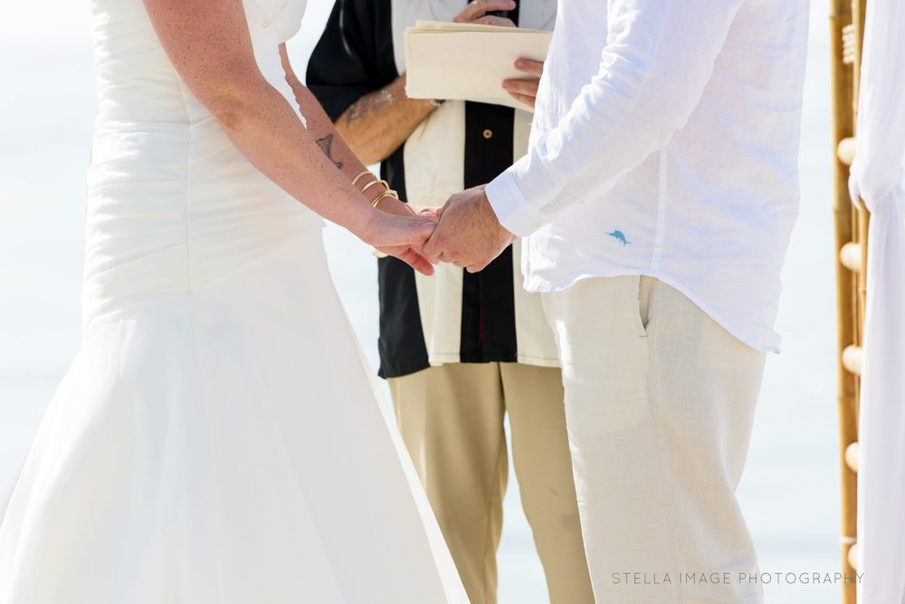 Bride and groom hold hands at the alter